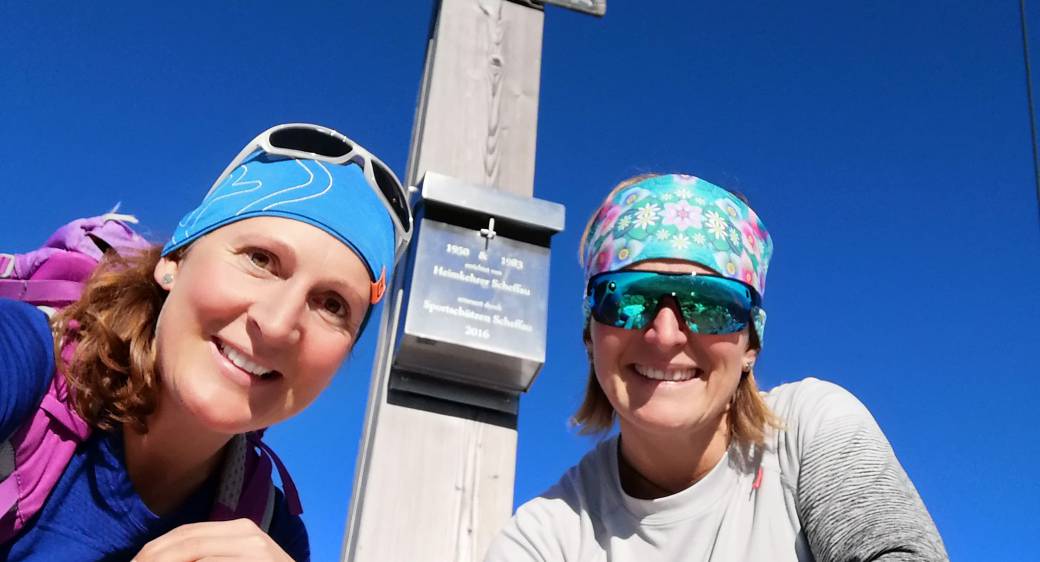 Two Hikers at the Summit Cross on the Wilder Kaiser