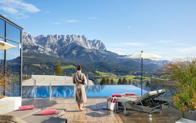 Žena v županu u nekonečného horského bazénu ve wellness zóně