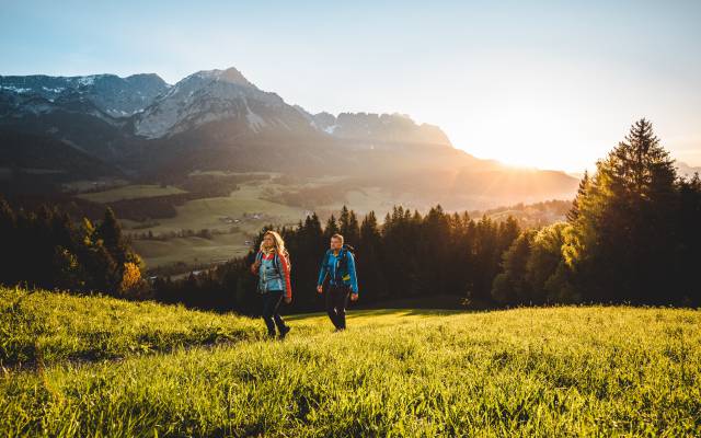 Hiking across alpine meadows at sunrise